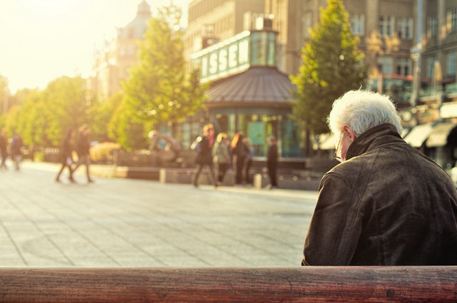 man-sitting-on-wooden-bench-wearing-black-leather-jacket-1377055